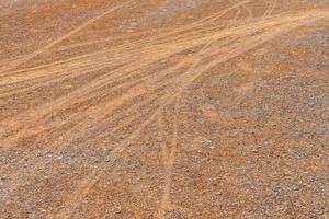 Pistas de tierra de motocicleta de rueda en el suelo. foto