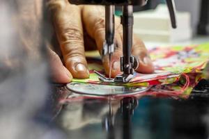 A close up, sewing the fabric on the old machine. photo