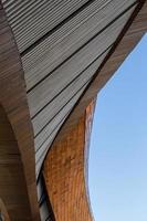 Low angle view, close-up, brown arched contemporary building exterior structure, abstract shape, distorted curves, a tourist attraction in a province of Thailand. photo
