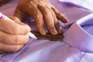 mano femenina sosteniendo un lápiz para dibujar una línea con una camisa blanca. foto