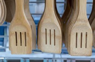 Many wooden ladle with hanging holes. photo