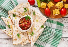 Mexican Quesadilla wrap with chicken, corn and sweet pepper and salsa photo