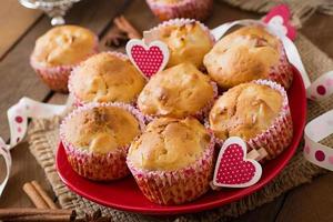 Fruit muffins with nutmeg and allspice in a wicker basket on a wooden background