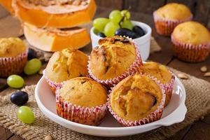 Appetizing and ruddy muffins with pumpkin and grapes