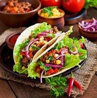 Mexican tacos with meat, vegetables and red onion photo