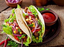 Mexican tacos with meat, vegetables and red onion photo