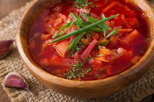 Traditional Ukrainian Russian vegetable borscht on the old wooden background photo