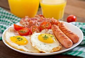 desayuno inglés - tostadas, huevo, tocino y verduras en un estilo rústico sobre fondo de madera foto