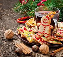 Warming mulled wine, spices and gingerbread cookie on a wooden background in rustic style photo