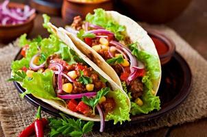 Mexican tacos with meat, vegetables and red onion photo