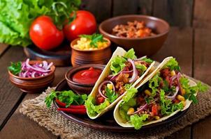 Mexican tacos with meat, vegetables and red onion photo