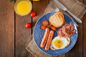 English breakfast - toast, egg, bacon and vegetables in a rustic style on wooden background photo