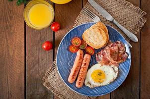 English breakfast - toast, egg, bacon and vegetables in a rustic style on wooden background photo