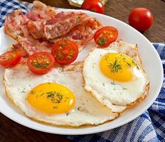 English breakfast - toast, egg, bacon and vegetables in a rustic style on wooden background photo