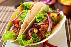 Mexican tacos with meat, vegetables and red onion photo