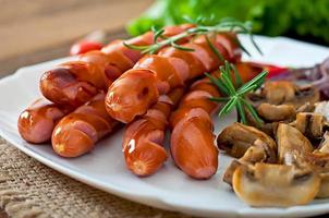 Fried sausages with vegetables on a white plate photo