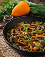 Stir frying beef with sweet peppers and green beans photo
