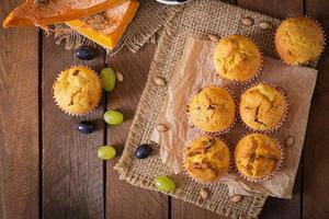 Appetizing and ruddy muffins with pumpkin and grapes photo