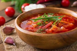 Traditional Ukrainian Russian vegetable borscht on the old wooden background photo