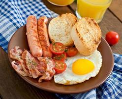 English breakfast - toast, egg, bacon and vegetables in a rustic style on wooden background photo