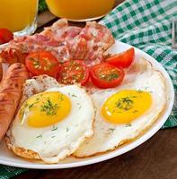 English breakfast - toast, egg, bacon and vegetables in a rustic style on wooden background photo