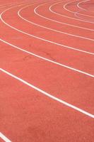 pista de atletismo para todo clima, carriles naranjas y blancos para entrenamiento de carrera foto