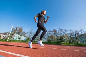 Young female runner training in summer day outdoors on the studium photo