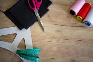 accesorios de costura, herramientas y telas en la mesa de la costurera foto