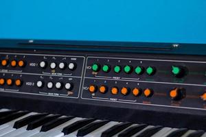 Old synthesizer with colorfull switches on blue background photo