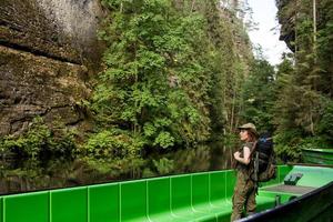 joven excursionista posando cerca del río en el parque nacional bohemio de suiza, viajera en las montañas de la república checa foto