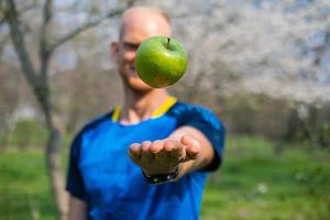 ajuste masculino con manzana verde en la mano foto