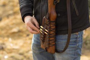 Male training with pump action shotgun outdoors in field. photo