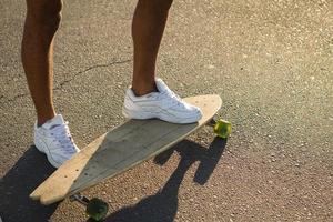 longboard skate stand alone on asphalt in yellow sunlight photo