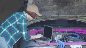 vrouwelijke monteur die auto in een garage repareert video
