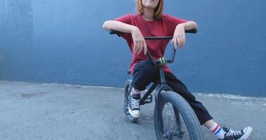 junge Frau posiert mit BMX Fahrrad im Freien auf der Straße video
