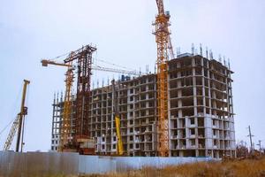 Concrete building in progress with cranes photo