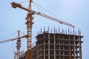 Concrete building in progress with cranes photo