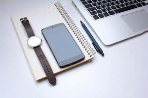 notebook on white table with gadgets and decorations, top view of writer, freelancer or buisinessman work place photo