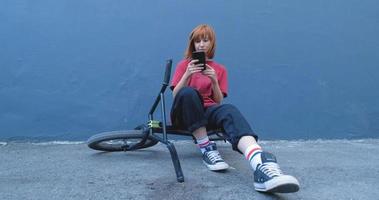 Mujer joven posando con bicicleta BMX al aire libre en la calle video