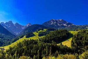 montañas con prados, bosques y cielo azul en flendruz, rougemo foto