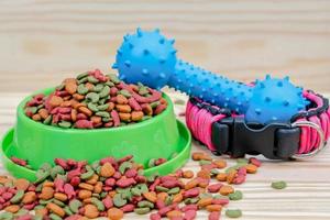 Pet food with rubber toy on wooden background photo