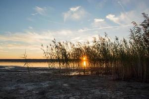 hermoso paisaje de verano con lago, colinas y puesta de sol foto