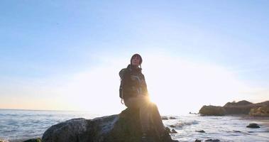 jonge vrouwelijke reiziger met rugzak en retro filmcamera reizen in de herfstbergen in de buurt van zee video