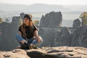 Youmg woman with backpack stand on the old german castle in saxon switzerland national park