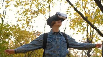 mujer joven feliz con gafas de realidad virtual divirtiéndose en el parque de otoño foto