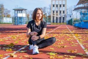 Young female runner training in summer day outdoors on the studium photo