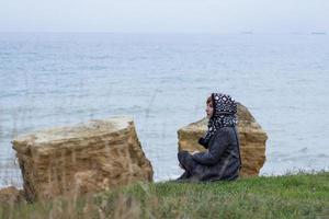 Young woman in grey coat against the autumn sea background photo