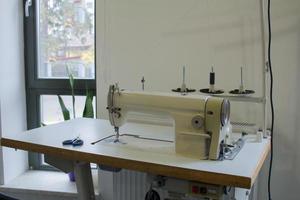 sewing machine on work table in tailor studio photo