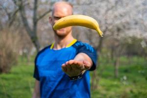 Fiy happy male with banana in hands photo