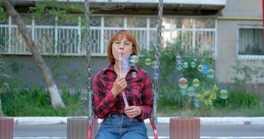 Young woman play with soap bubbles outdoors video